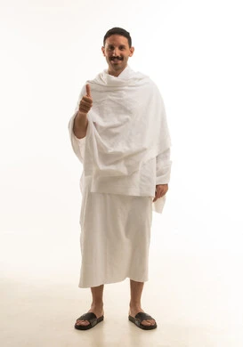 رجل سعودي بملابس الإحرام يرفع إبهامه علامة الرضا رجل سعودي بملابس الإحرام يرفع إبهامه علامة الرضا