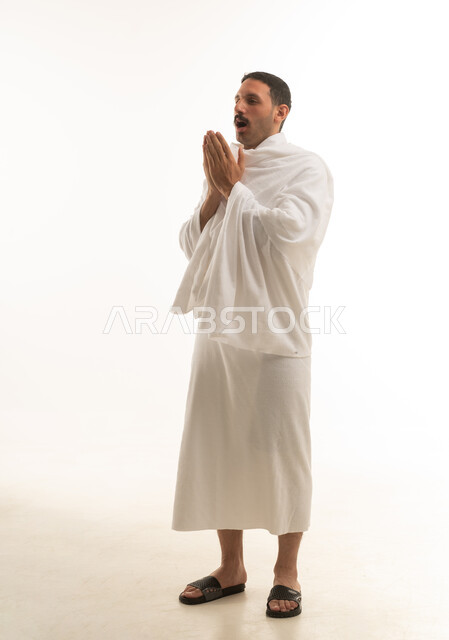 رجل سعودي بملابس الإحرام يدعو الله