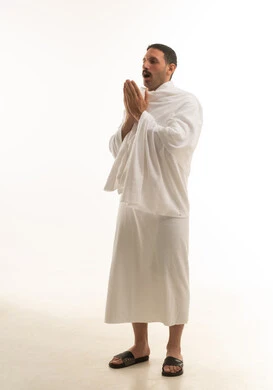 رجل سعودي بملابس الإحرام يدعو الله