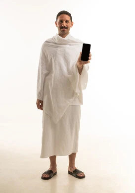 Saudi Man in Ihram Holding Smartphone with Blank Screen