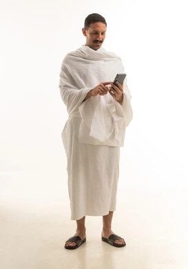 Saudi Man in Ihram Using Smartphone on White Background