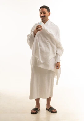 رجل سعودي بملابس الإحرام يمسك زجاجة مياه