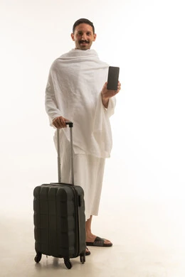 Saudi Man in Ihram with Smartphone and Suitcase