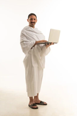 رجل سعودي بملابس الإحرام يحمل لابتوب خلفية بيضاء