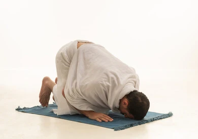 رجل سعودي بملابس الإحرام يؤدي السجود