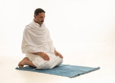 Saudi Man in Ihram Sitting on Prayer Mat