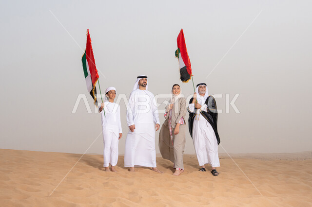 A traditional atmosphere reflecting authenticity and national belonging, the concept of pride and national unity, celebrating national identity and belonging. An Emirati Gulf Arab family wearing traditional dress stands in the desert raising the flag of the United Arab Emirates, looking at something.