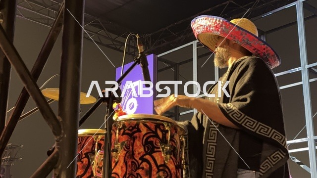A musical performance with folkloric costumes and drumming at a food festival in the outdoor Ithra Gardens in Dhahran, Eastern Province, Saudi Arabia, on December 28, 2025. Family-friendly and entertaining atmosphere, a recreational and educational experience, international and local restaurants, enjoyable outdoor seating.