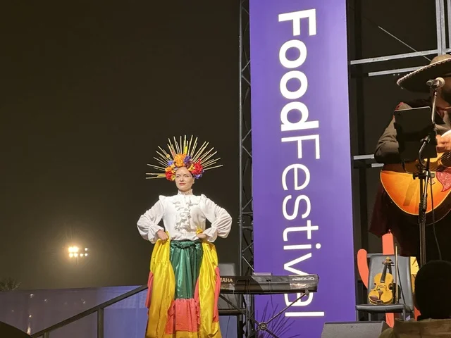 A musical performance with folkloric costumes and drumming at a food festival in the outdoor Ithra Gardens in Dhahran, Eastern Province, Saudi Arabia, on December 28, 2025. Family-friendly and entertaining atmosphere, a recreational and educational experience, international and local restaurants, enjoyable outdoor seating.
