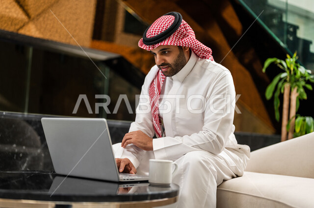 رجل خليجي سعودي بداخل احدى الفنادق السياحية ، إستخدام جهاز الحاسوب المحمول لإنجاز المهام ، مفهوم التكنولوجيا وإستخدام أجهزة تقنية حديثة، العمل عن بعد ، مهن ووظائف ، جلسة عمل ، مفهوم إدارة الأعمال، رحلة عمل، سياحة وفندقة ، التسويق الإلكتروني