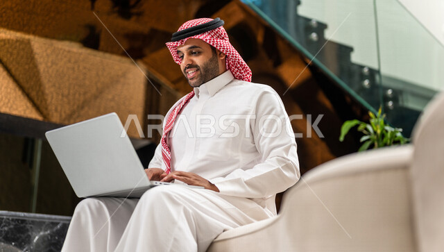 رجل خليجي سعودي بداخل احدى الفنادق السياحية ، إستخدام جهاز الحاسوب المحمول لإنجاز المهام ، مفهوم التكنولوجيا وإستخدام أجهزة تقنية حديثة، العمل عن بعد ، مهن ووظائف ، جلسة عمل ، مفهوم إدارة الأعمال، رحلة عمل، سياحة وفندقة ، التسويق الإلكتروني