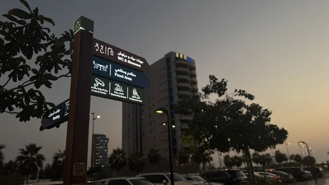 Guidance signs at the Abhur waterfront on the northern corniche of Jeddah, Saudi Arabia, a tourist and recreational marine destination, a coastal promenade with open views of the Red Sea, restaurants and cafes overlooking the waterfront, various recreational activities, and a calm and distinctive family atmosphere.