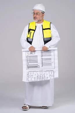 مهندس إماراتي يحمل مخطط بناء في استوديو مهندس إماراتي يحمل مخطط بناء في استوديو