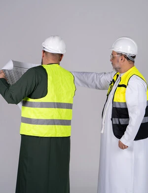 Emirati Engineers Reviewing Blueprints in Safety Gear