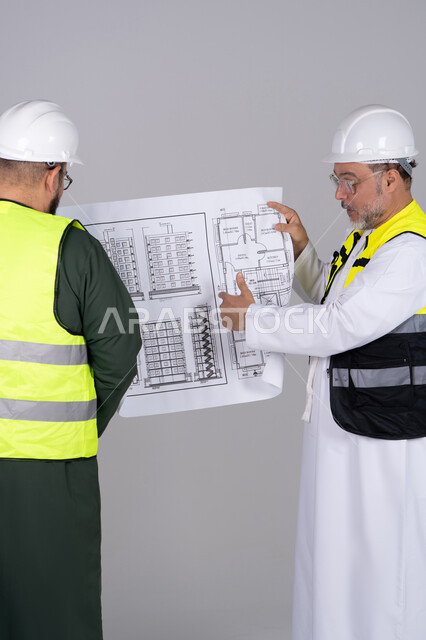 مهندسون إماراتيون يراجعون مخططاً معمارياً في استديو