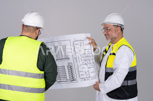 مهندسون إماراتيون يفحصون مخططات البناء المعمارية
