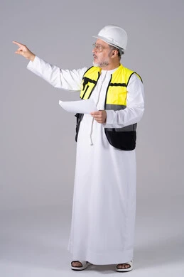 مهندس إماراتي يرتدي سترة السلامة ويشير بيده مهندس إماراتي يرتدي سترة السلامة ويشير بيده