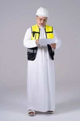 مهندس إماراتي بملابس السلامة يقرأ مخطط ورقي مهندس إماراتي بملابس السلامة يقرأ مخطط ورقي