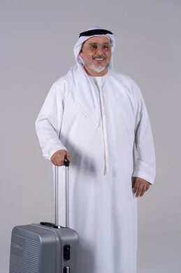 رجل إماراتي مسن يبتسم مع حقيبة سفر صورة كاملة