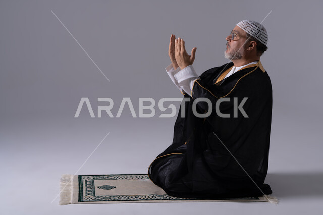 رجل إماراتي بالبشت التقليدي يؤدي الدعاء