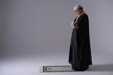 Emirati Man Praying in Traditional Black Bisht