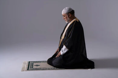 Emirati Man Praying on Rug in Studio Setting