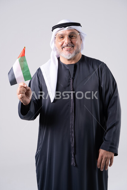 Emirati Man Holding UAE Flag on Gray Background