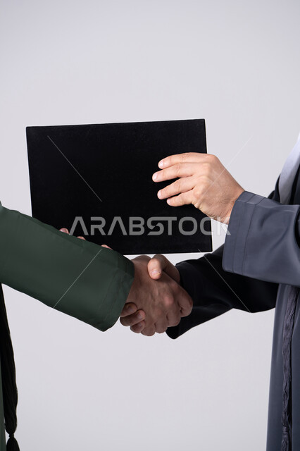 مصافحة رجال إماراتيين مع ملف شهادة أسود