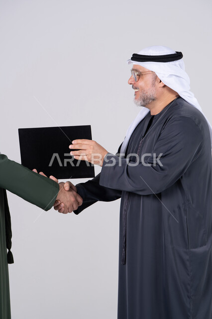 رجل أعمال إماراتي يتصافح مع مجلد مستندات