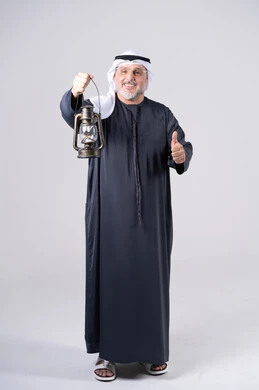 رجل إماراتي يحمل فانوساً مع إشارة الإبهام للأعلى