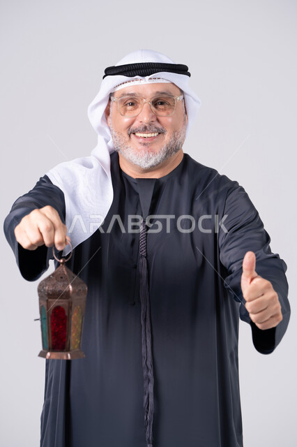 رجل إماراتي يحمل فانوس رمضان مع إيماءة الإعجاب