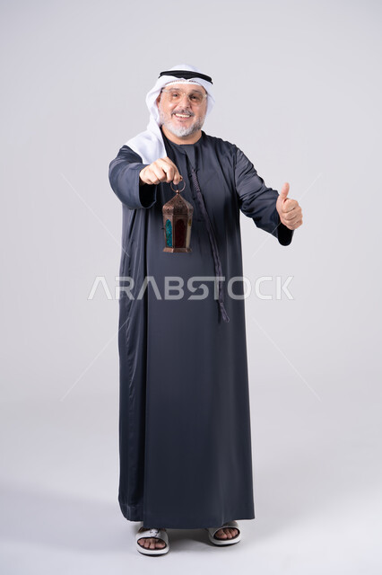 رجل إماراتي يحمل فانوس رمضان مع علامة الإعجاب