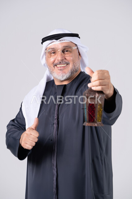 رجل إماراتي يحمل فانوس رمضان مع إشارة الإعجاب