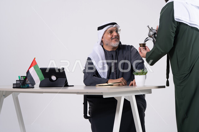 Emirati Businessman Drinking Arabic Coffee at Office Desk
