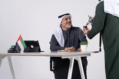 رجل أعمال إماراتي يشرب القهوة العربية في المكتب