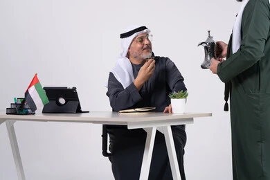 رجل أعمال إماراتي يشرب القهوة العربية في المكتب
