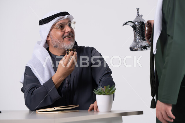 رجل إماراتي يشرب القهوة العربية في مكتب عمل