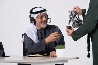 رجل إماراتي في المكتب يتلقى خدمة القهوة العربية