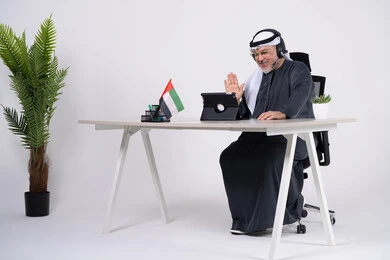 رجل إماراتي في مكتب العمل خلال مكالمة فيديو