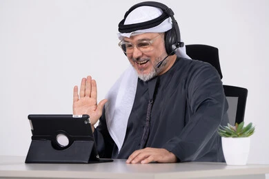 رجل إماراتي يرتدي سماعة رأس في مكالمة فيديو