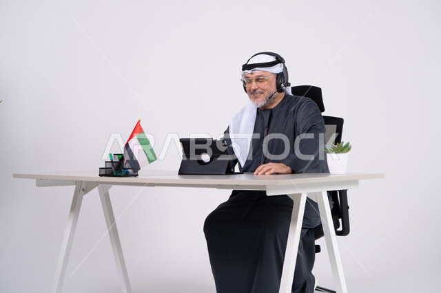 Emirati Man Working on Tablet with Headset in Office