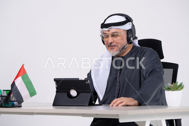 رجل أعمال إماراتي يجري مكالمة فيديو في المكتب