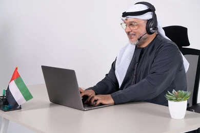 رجل إماراتي يعمل على كمبيوتر محمول في المكتب