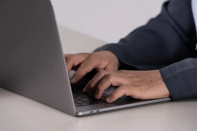 يدي رجل أعمال إماراتي يكتب على لوحة مفاتيح الكمبيوتر