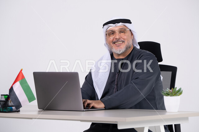 رجل أعمال إماراتي يعمل على اللابتوب في المكتب