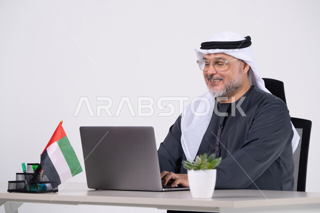 رجل أعمال إماراتي يعمل على كمبيوتر محمول