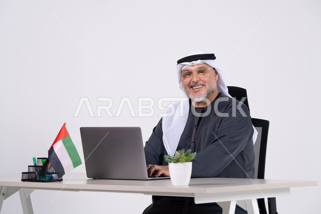 رجل أعمال إماراتي مع لابتوب على مكتب عمل