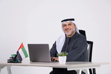 رجل أعمال إماراتي مع لابتوب على مكتب عمل