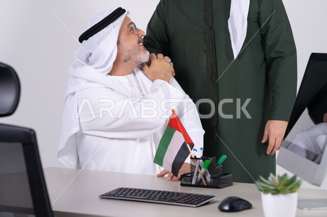 رجل أعمال إماراتي بالكندورة التقليدية في مكتبه