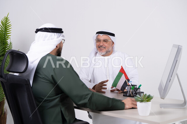 رجال أعمال إماراتيون باللباس التقليدي في المكتب